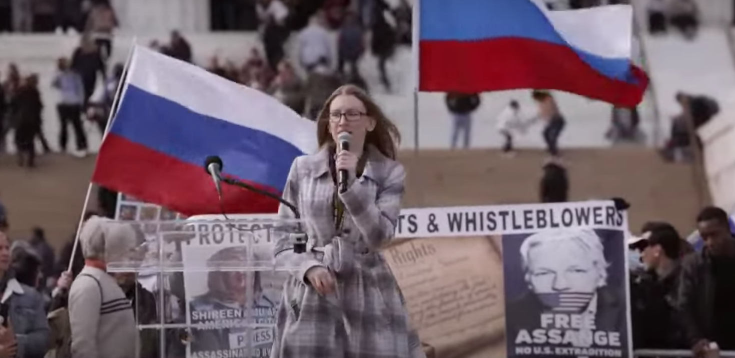 Libertarian Party Chair Angela McArdle speaking before Russian flags. (Libertarian Party on YouTube)